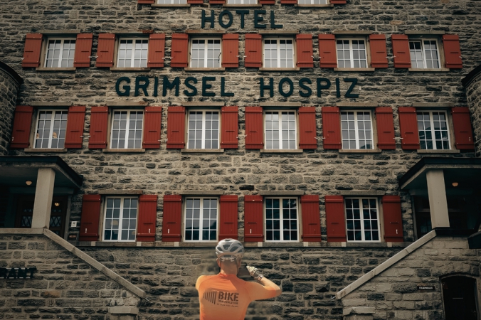 Bike Tour Evolution cyclist in front of Hotel Grimsel Hospiz at Grimsel Pass, 2165m Switzerland