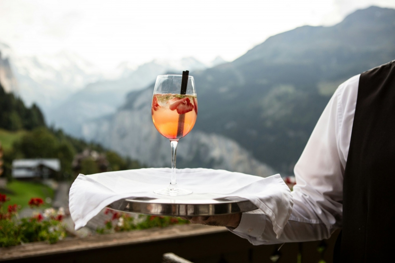 Cameriere con un vassoio che serve un aperitivo gourmet durante unesperienza gastronomica di lusso Bike Tour Evolution