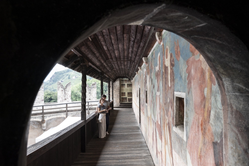 Coppia che ammira gli affreschi medievali di Castel Roncolo durante una visita guidata culturale Bike Tour Evolution
